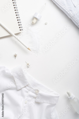 White monochromatic flatlay on white background. Clothes, accessories, stationery and beauty equipment. Blog design concept