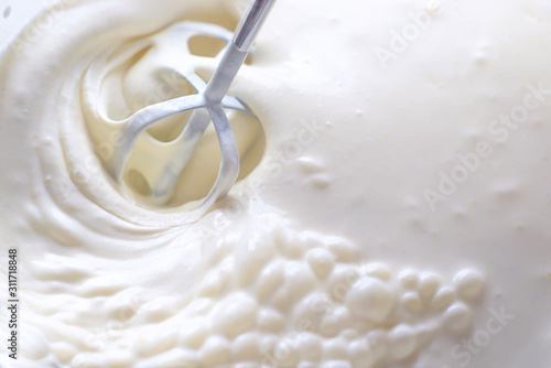 Fototapeta Whipping cream with a mixer. Bubbles on cream