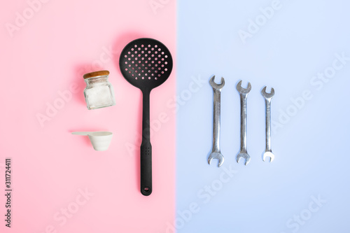 Gender stereotypes: division of men and women specific tasks or activities. Kitchenware opposed to mechanic repair tools in studio background photo