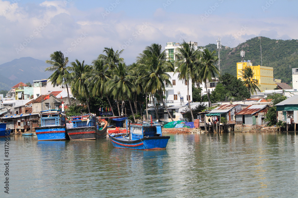 Vietnam, Nha Trang - December 11, 2019-Traditional houses, boats and river in Nha Trang. Vietnam, Nha Trang - December 11, 2019-Traditional houses, boats and river in Nha Trang.