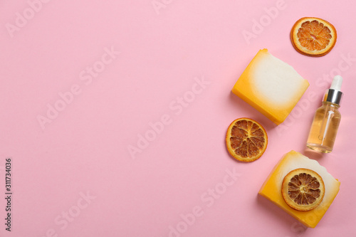 Flat lay composition with natural handmade soap and ingredients on pink background. Space for text