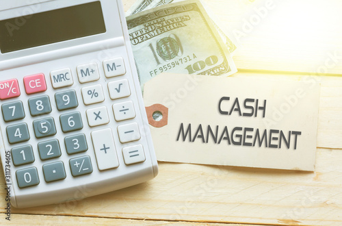 CASH MANAGEMENT Words on tag with dollar note and calculator on wood backgroud,Finance Concept