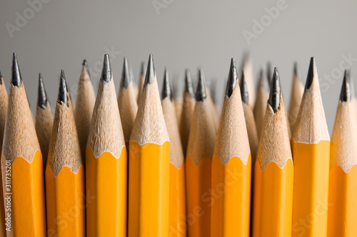 Sharp graphite pencils on grey background, closeup photo