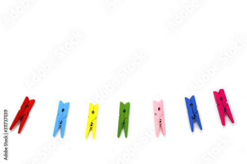 Many color wooden clip isolated white background - for hanging items - red blue pink green yellow color - minimal patterns
