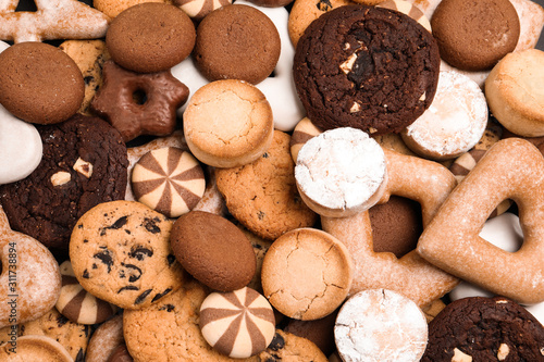 Different delicious cookies as background, top view