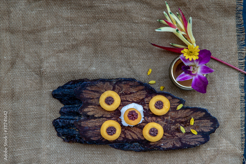 Traditional Thai Dessert (Kanom Thai) : Sanay Chan Made from minced coconut mixed with flour, sugar, egg yolk, rice flour and chan herb serving in a dark wooden. photo