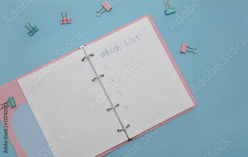 A wish list. Open notebook on a blue background.