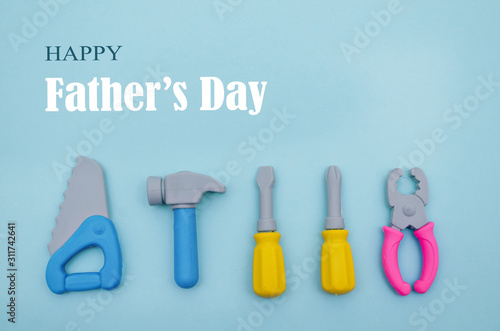 Conceptual flat lay for holiday Father's Day. Mini tools workers on a blue background.