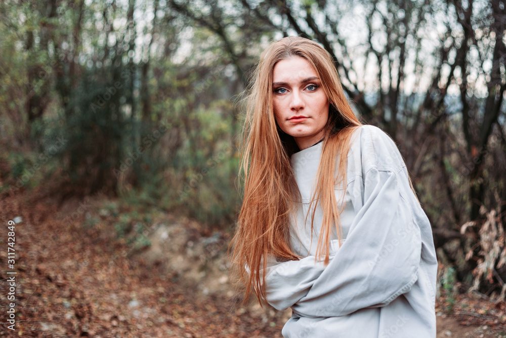 Girl with long hair in straitjacket, outside in the woods. Mental breakdown Girl with long hair in straitjacket, outside in the woods. Mental breakdown
