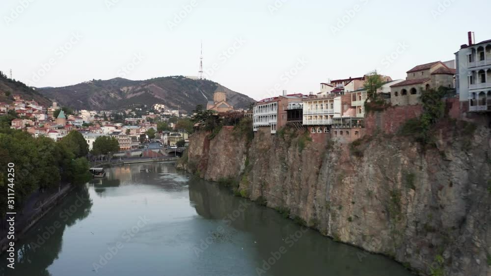 View over Kura river and buildings on rocky slope in Tbilisi city drone footage. View over Kura river and buildings on rocky slope in Tbilisi city drone footage.
