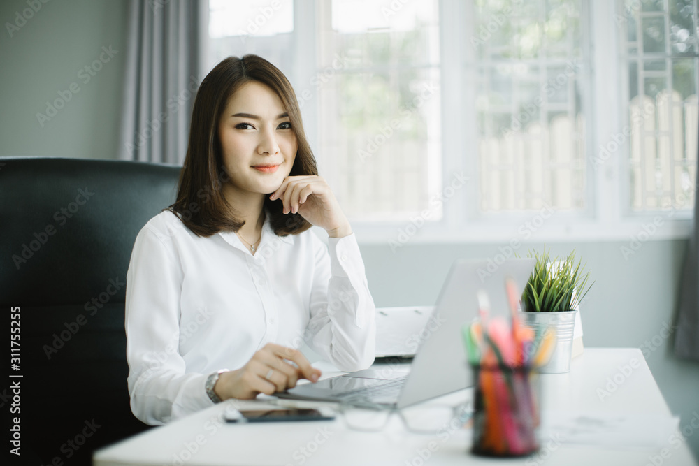 Beautiful young woman working on her laptop in her office. Beautiful young woman working on her laptop in her office.