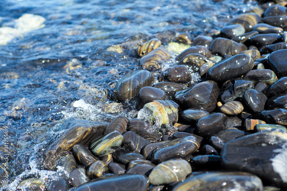 Closeup group of wet polished stones and pebbles were surfed by the sea Closeup group of wet polished stones and pebbles were surfed by the sea