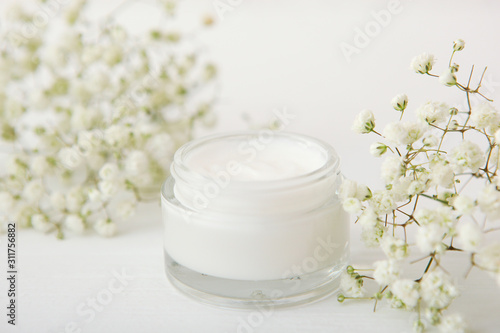 skincare cream and flowers on the table. Cosmetics for skin care.