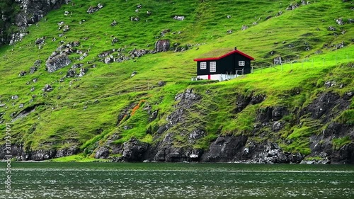 Traditional turf-top faroese house on Pollurin Laguna, Saksun village, Atlantic ocean coast, Streymoy island, Faroe Islands, Denmark. UHD 4k video