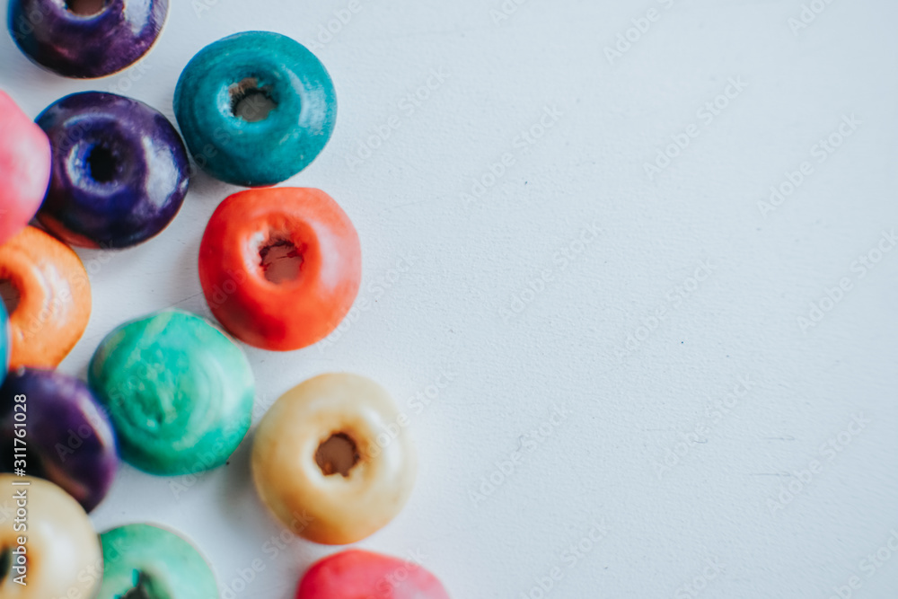 colorful wooden beads on a white table with copyspace colorful wooden beads on a white table with copyspace