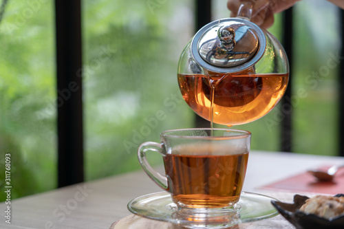 Foto Tea set in clear glass jug and dessert