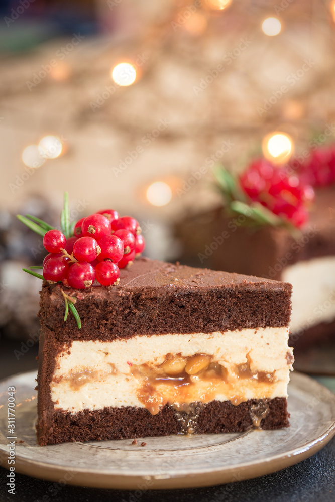 Chocolate cake with peanut butter mousse, caramel and peanuts. Decorated with red currants and rosemary. Homemade. Chocolate cake with peanut butter mousse, caramel and peanuts. Decorated with red currants and rosemary. Homemade.