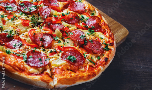Pepperoni Pizza with Mozzarella cheese, salami, pepper. Spices and Fresh basil. Italian pizza on wooden table background photo