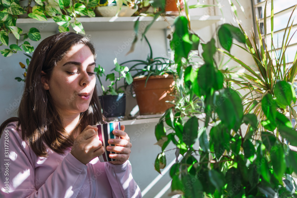 Young white woman drinking coffee on a balcony Young white woman drinking coffee on a balcony