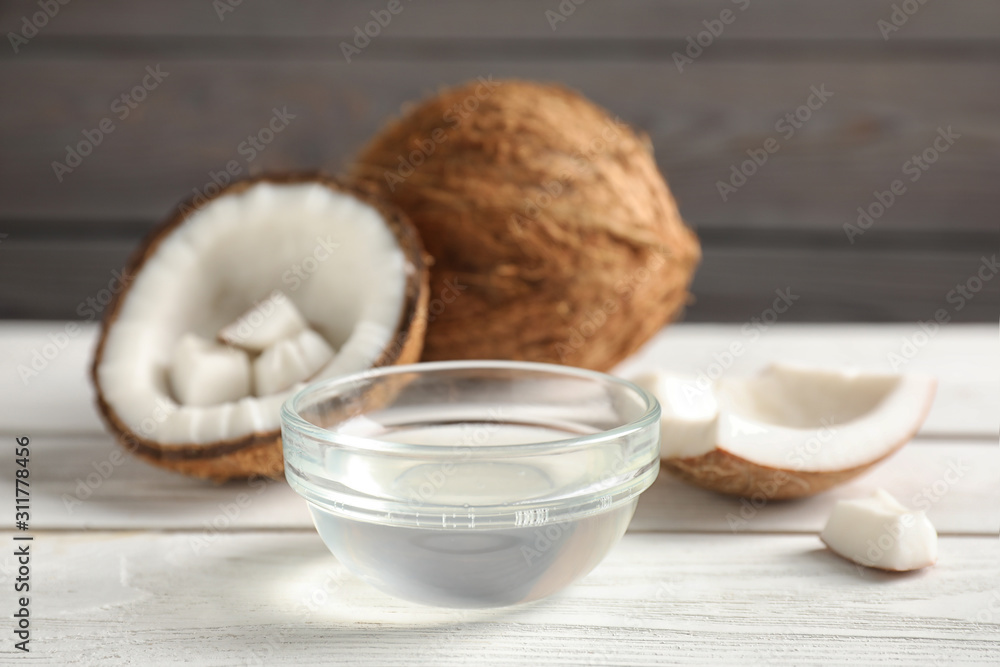 Coconut oil in bowl on white wooden table Coconut oil in bowl on white wooden table