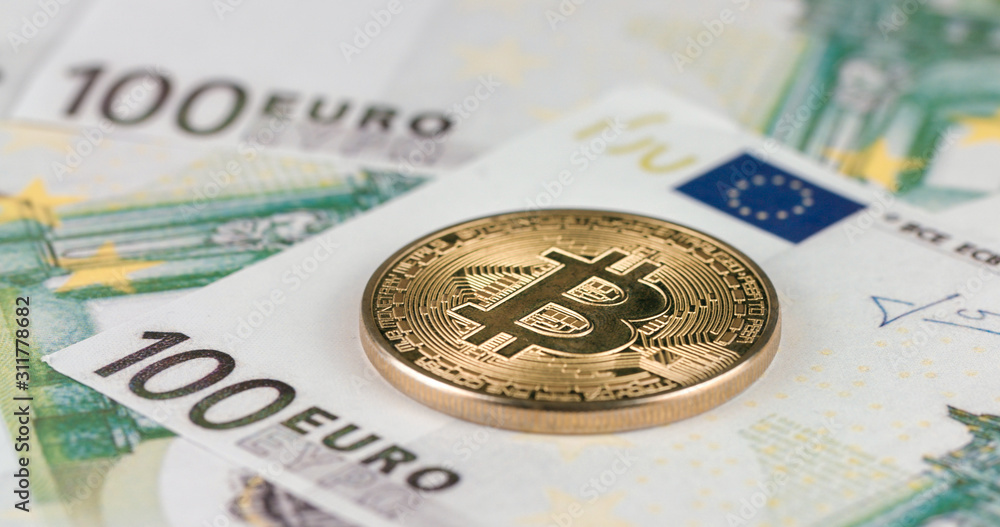 Cryptocurrency gold Bitcoin coin on a hundred euro bills. Close-up, macro shot Cryptocurrency gold Bitcoin coin on a hundred euro bills. Close-up, macro shot