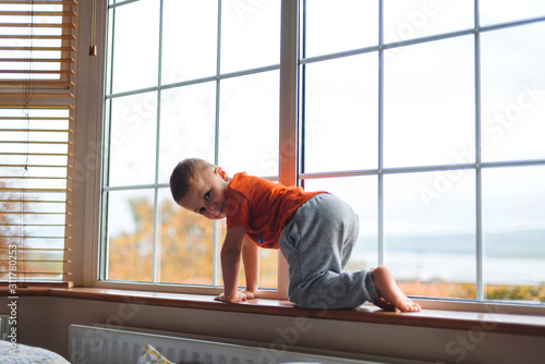 Wallpaper Mural smiling boy on window sill Torontodigital.ca