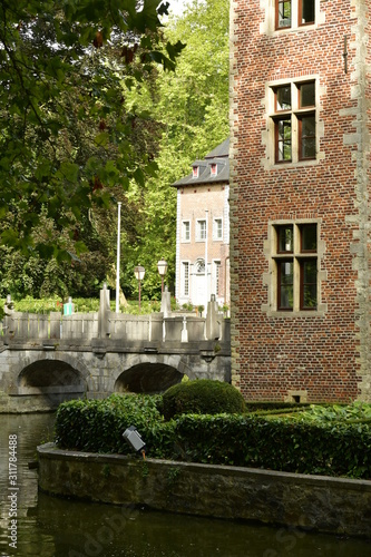 Un coin du ch  teau avec l une de ses d  pendances et le pont en pierres sous la nature luxuriante du domaine Coloma    Sint-Pieter-Leeuw