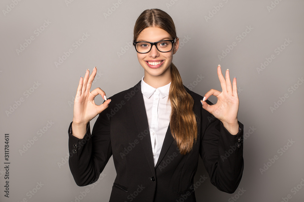 businesswoman showing okey signs isolated on grey businesswoman showing okey signs isolated on grey