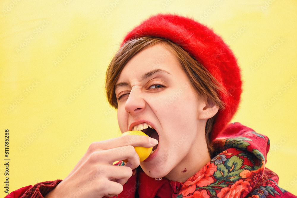 Portrait of a beautiful young woman dressed in red posing with lemon Portrait of a beautiful young woman dressed in red posing with lemon