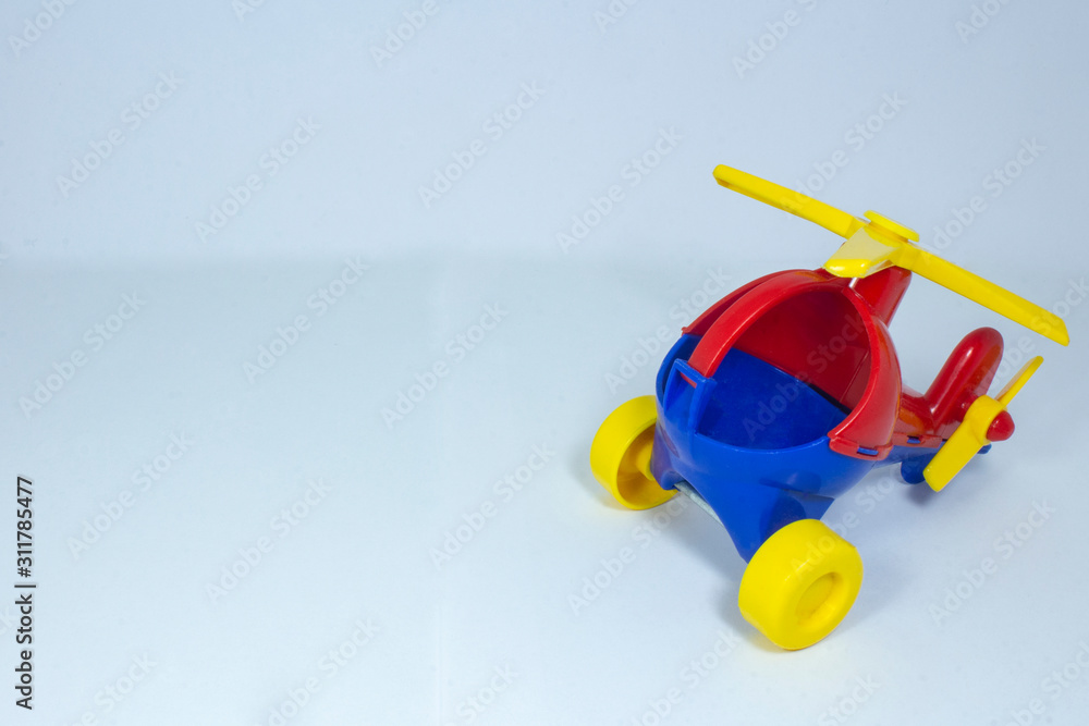 Children's toy, plastic red-blue helicopter with a yellow propeller and wheels on a gray fleecy background.. Children's toy, plastic red-blue helicopter with a yellow propeller and wheels on a gray fleecy background..