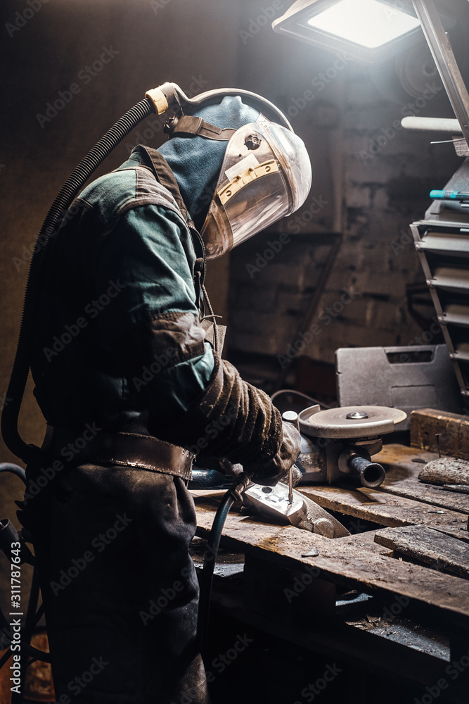 Portrait of busy working man at his workplace at the metal factory.
