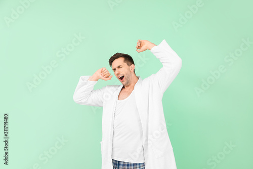 Sleepy man in bathrobe on c...