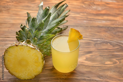 Fresh cut pineapple and juice on wooden background