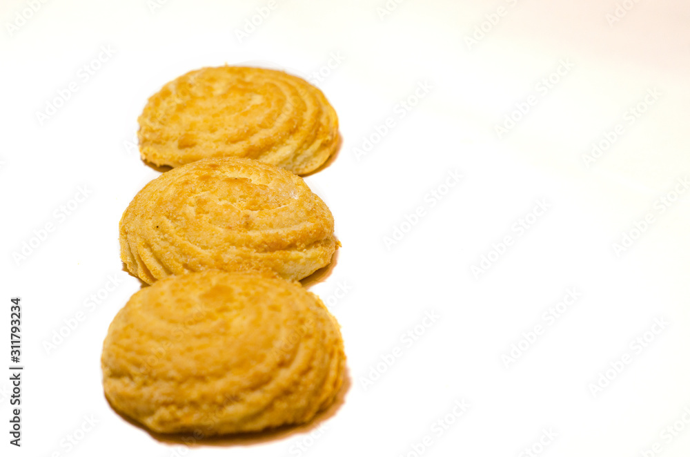 Three delicious round cookies lie on a white background in a row. Selective focus. Three delicious round cookies lie on a white background in a row. Selective focus.