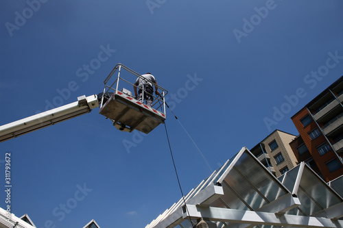 worker of Professional Facade Cleaning Services washing a galss roof