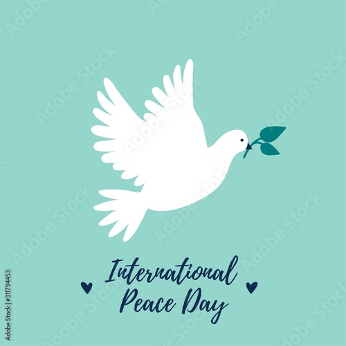 White Dove flying and holding green leaves as peace symbol for International Peace Day.