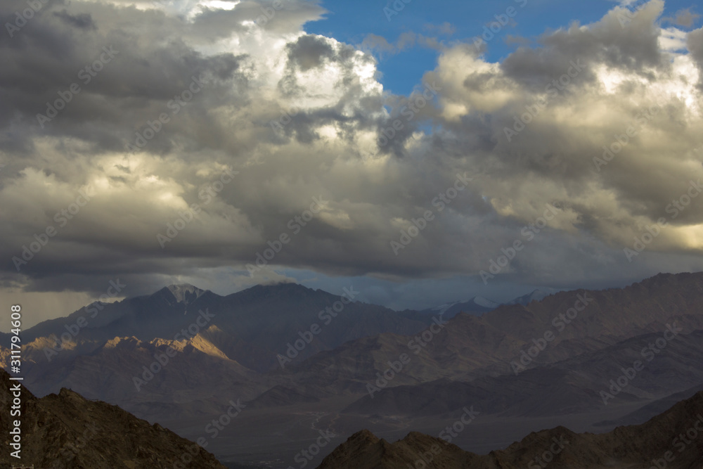 dark silver clouds in the evening sky over the mountains with snowy peaks