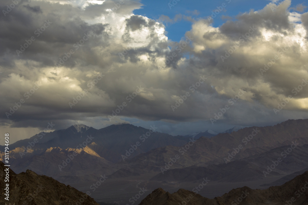 dark silver clouds in the evening sky over the mountains with snowy peaks dark silver clouds in the evening sky over the mountains with snowy peaks