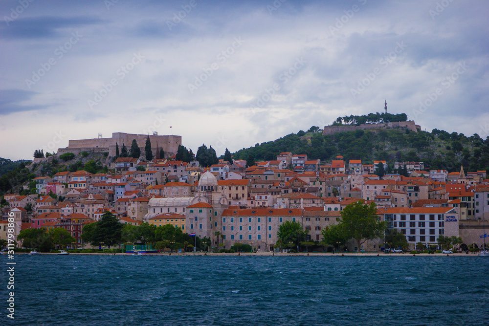 Sibenik, Croatia / 18th May 2019 : Seafront view of Sibenik cathedral st James and fort at stormy day