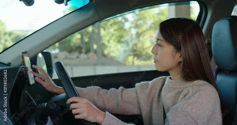 Woman set gps location on cellphone inside a car Woman set gps location on cellphone inside a car
