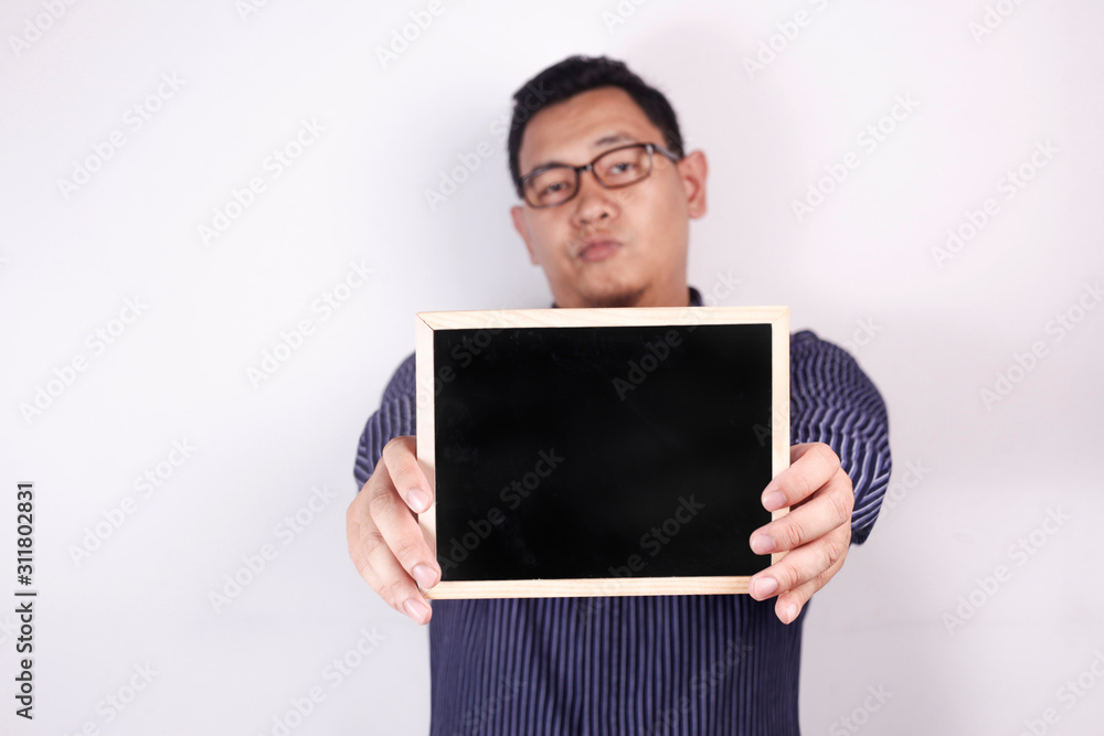 Man shows empty blackboard with annoyed expression Man shows empty blackboard with annoyed expression