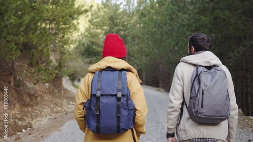 Wallpaper Mural Traveling couple with backpacks walking in forest. slow motion	 Torontodigital.ca