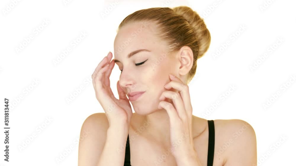 Young beautiful model in a sensual way touching and stroking her face gently. Isolated on white background. Young beautiful model in a sensual way touching and stroking her face gently. Isolated on white background.