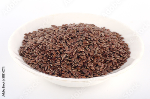 close up of flax seeds in white plate isolated on white background