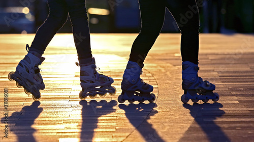 silhouette of two pairs of legs on roller skates