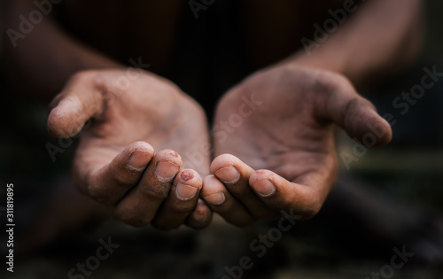 poor child or beggar begging you for help sitting at dirty slum. concept for poverty or hunger people,human rights,donate and charity for underprivileged children in third world