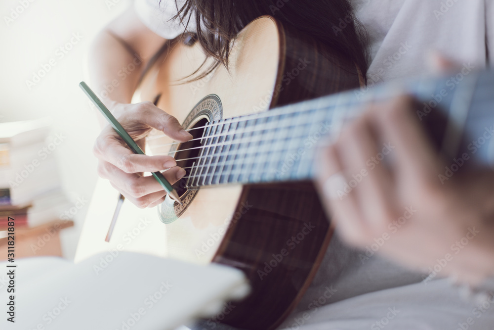 Fototapeta premium artist songwriter thinking writing notes,lyrics in book at studio.man playing live acoustic guitar relax chill.concept for musician creative.composer work process.people relaxing time with instrument