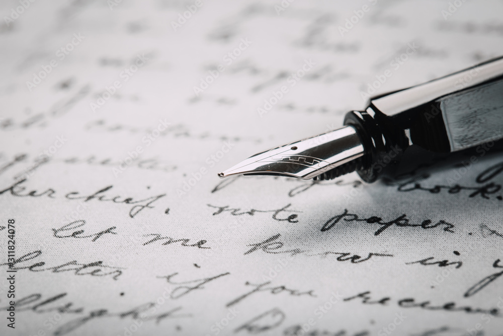 Fototapeta premium Fountain pen on an ancient handwritten letter. Old story. Retro style.