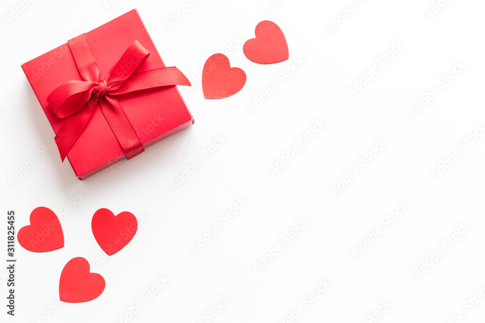 Gift to a sweetheart on Valentine's Day. Red present box near hearts on white background top-down copy space