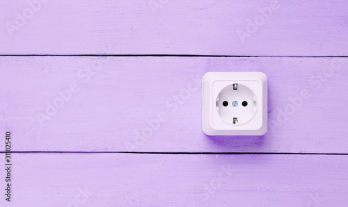 Power socket on purple wooden wall, minimalism